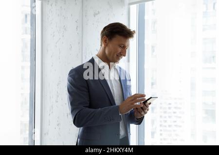 Uomo d'affari felice che utilizza l'app virtuale sullo smartphone Foto Stock