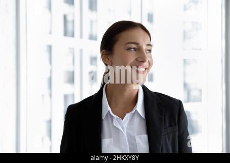 Felice professionista di affari che posa al vetro della finestra dell'ufficio Foto Stock
