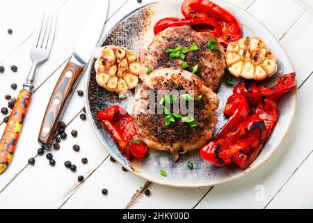 Bistecca o cotoletta di manzo alla griglia, manzo e maiale con spezie. Carne succosa alla griglia con pancetta. Foto Stock