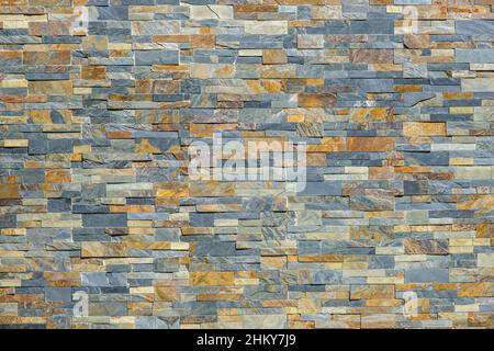 Pietra impilato il rivestimento di facciata di edificio per texture di sfondo Foto Stock