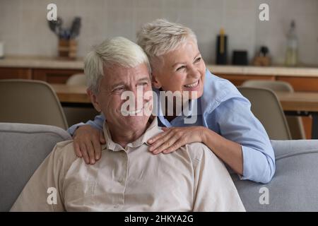 Coppia sposata anziana allegra che si rilassa nel soggiorno di casa Foto Stock
