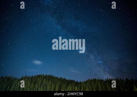 Paesaggio notturno con campo sulle colline e cielo Via Lattea. Foto Stock