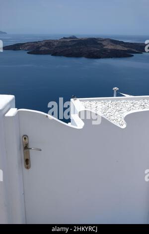 Santorini, Grecia - 7 maggio 2021 : porta e scalini che conducono ad un edificio residenziale con una splendida vista sul Mar Egeo e sul vulcano di Santor Foto Stock