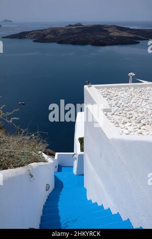 Santorini, Grecia - 7 maggio 2021 : porta e scalini che conducono ad un edificio residenziale con una splendida vista sul Mar Egeo e sul vulcano di Santor Foto Stock