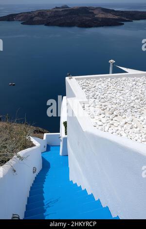 Santorini, Grecia - 7 maggio 2021 - scalinata blu che conduce ad un edificio residenziale con una bella vista sul Mar Egeo e sul vulcano di Santor Foto Stock