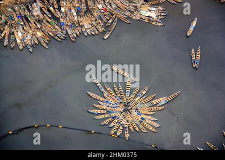 Vista aerea delle barche da pesca ormeggiate insieme nel porto di Temi, Greater Accra, Ghana, formando un motivo floreale sulle acque sporche Foto Stock