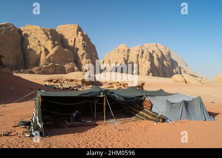 Bellissimo scatto di alcuni campi vicino ad alcune enormi scogliere a Wadi Rum, Giordania. Foto Stock