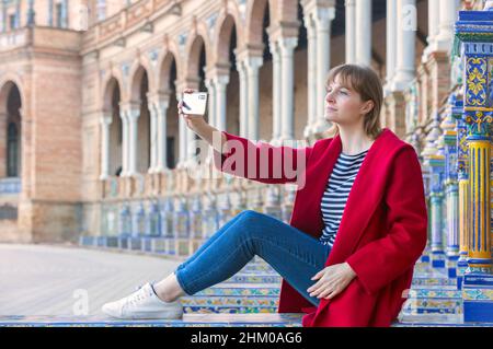 donna bionda turista che prende un selfie in plaza de españa a siviglia Foto Stock