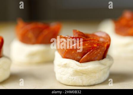 torta di peperoni a forma di rosa, pasta con salame, pasta sfoglia fatta in casa pronta per la cottura. Foto Stock