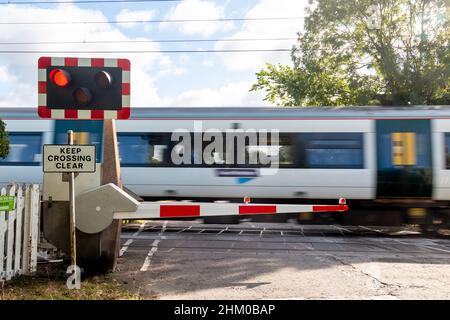 Un treno del Grande Nord supera un incrocio a livello chiuso vicino ad Harston in Cambridgeshire, Regno Unito Foto Stock