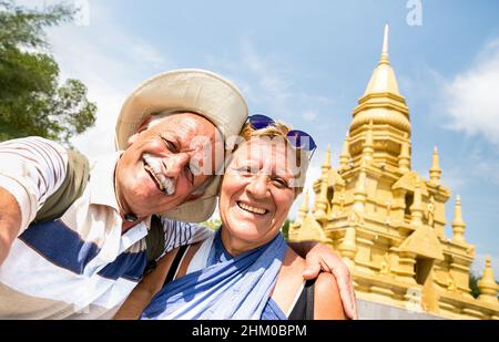 Coppia anziana che prende selfie al tempio d'oro a Ko Samui - Happy pensionati che viaggiano in Thailandia meraviglie - Active anziani concetto e divertimento intorno Foto Stock