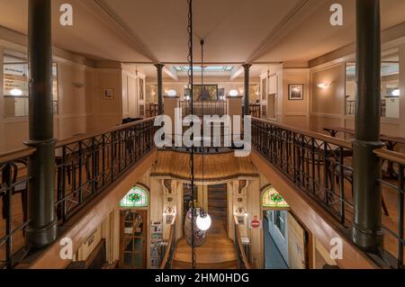 Brussels Old Town, Brussels Capital Region, Belgium - 02 02 2022: Vista panoramica su un ristorante con mobili in legno, vetrate colorate e specchi Foto Stock