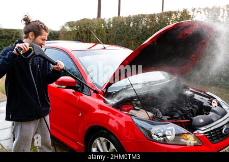 Woodbridge, Suffolk, UK Febbraio 24 2021: Un giovane uomo a pressione lavando la sua auto pulita Foto Stock