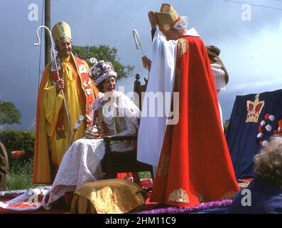 1977, storica, sul retro di un trattore, una sfilata galleggiante con una donna e due uomini vestiti in costume come sacerdoti e la regina che celebra il giubileo d'argento della regina Elisabetta II, Inghilterra, Regno Unito. Foto Stock