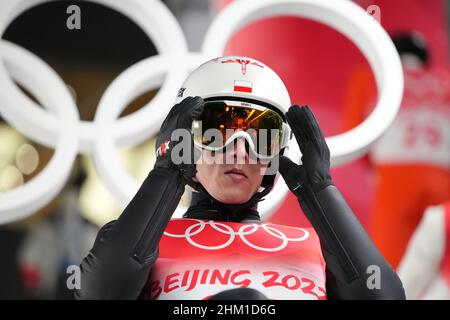 (220206) -- ZHANGJIAKOU, 6 febbraio 2022 (Xinhua) -- Dawid Kubbacki di Polonia regola i suoi occhiali durante il normale giro di prova di salto di sci di collina degli uomini presso il National Ski Jumping Center di Zhangjiakou, provincia di Hebei della Cina settentrionale, 6 febbraio 2022. (Matthias Schrader/AP/piscina via Xinhua) Foto Stock