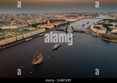 Paesaggio aereo con navi da guerra nel fiume Neva prima della vacanza della Marina russa al mattino presto, navi da guerra passano sotto un ponte levatoio sollevato, il Foto Stock