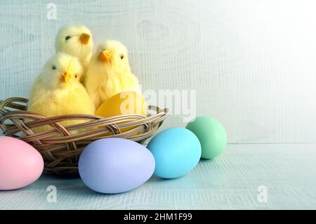 Uova di Pasqua e pulcini gialli su sfondo grigio. Il concetto minimo. Carta di Pasqua. Concetto di vacanza. Foto Stock