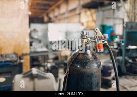 Bombola di ferro per la saldatura di prodotti su sfondo industriale. Foto Stock