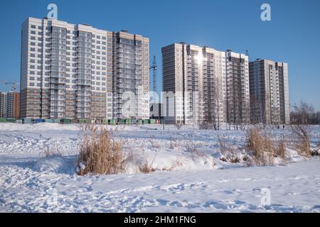 Alti edifici nella nuova area, paesaggio invernale coperto di neve, Russia. Foto Stock