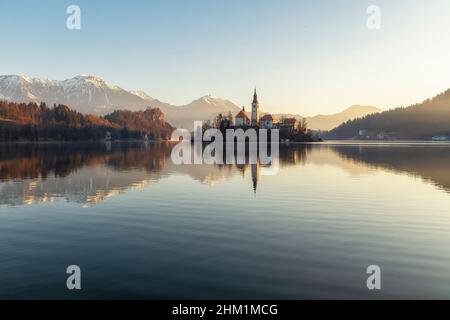 Splendida vista sul lago di Bled, il più famoso lago sloveno e l'isola di Bled con il pellegrinaggio Chiesa dell'Assunzione di Maria e del castello di Bled all'alba Foto Stock