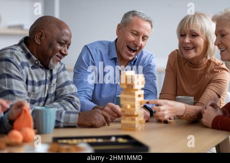 Gente anziana allegra che paga i giochi da tavolo insieme Foto Stock