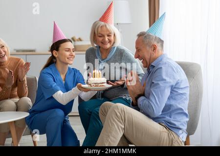 Amici anziani allegri che festeggiano il compleanno a casa di riposo Foto Stock