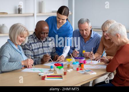 Creativi uomini e donne anziani che fanno arti e mestieri insieme Foto Stock