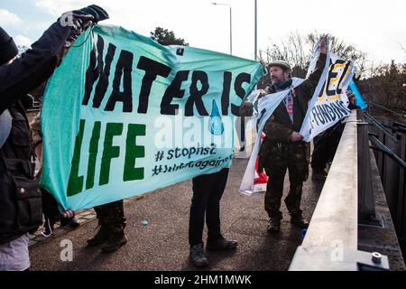 Ickenham, Regno Unito. 5th Febbraio, 2022. Stop HS2 gli attivisti attraversano un ponte sopra il A40 durante una passeggiata di protesta dell'acqua dal centro civico di Hillingdon a Harefield Moor per evidenziare il rischio di contaminazione per l'approvvigionamento pubblico di acqua potabile dalla perforazione nella falda acquifera di gesso nella valle di Colne per il treno ad alta velocità HS2 collegamento. Credit: Mark Kerrison/Alamy Live News Foto Stock