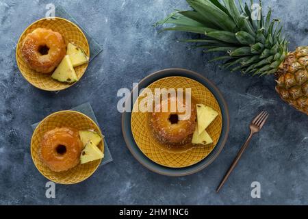 Vista dall'alto di porzioni di torta all'ananas capovolta e fette di ananas. Foto Stock