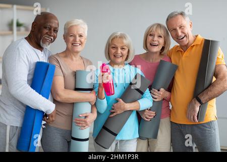 Gruppo di pensionati atletici che frequentano la lezione di yoga presso il centro di ritiro Foto Stock