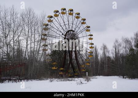Pripyat, zona di esclusione di Chernobyl, Ucraina. 6th Feb 2022. Il parco divertimenti che non ha mai aperto nella città abbandonata di Pripyat nella zona di esclusione di Chernobyl il 6 febbraio 2022 in Ucraina. Il russo continua il suo accumulo militare attraverso il confine in Bielorussia, a 15 chilometri dalla zona di esclusione di Chernobyl. Il modo più veloce per Kyiv da nord è attraverso la Bielorussia, direttamente attraverso questa zona, una distanza di 120 chilometri. Il disastro di Chernobyl è stato un incidente nucleare avvenuto il 26 aprile 1986 al reattore n. 4 nella centrale nucleare di Chernobyl, vicino alla città di Pripyat nella Foto Stock
