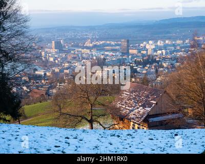 Vista su un antico casale verso la città di Zug, Svizzera, in un soleggiato pomeriggio invernale Foto Stock