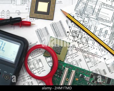 Scheda elettronica, matita, processori e multimetro sullo sfondo dello schema elettrico e di una fotomaschera. Concetto per lo sviluppo e la progettazione di Foto Stock