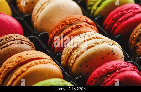 Macaron francese colorato sfondo, primo piano. Diversi macaroon colorati in gustoso colore dolce - immagine concetto panetteria Foto Stock