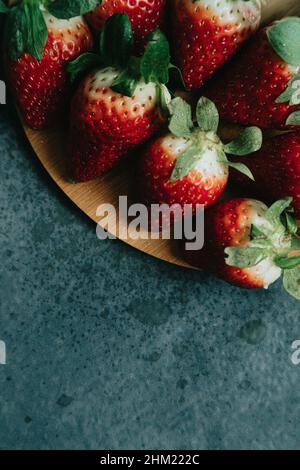 Alcune fragole su una tavola di legno con un aspetto delizioso Foto Stock