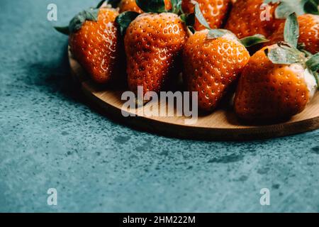 Alcune fragole su una tavola di legno con un aspetto delizioso Foto Stock