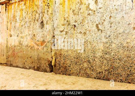 Fondo parete di calcestruzzo, tracce di agenti atmosferici, usura parete danni vernice vernice vecchia. Resti di vernice vecchia sulla superficie di calcestruzzo verniciata. Grungy concre Foto Stock