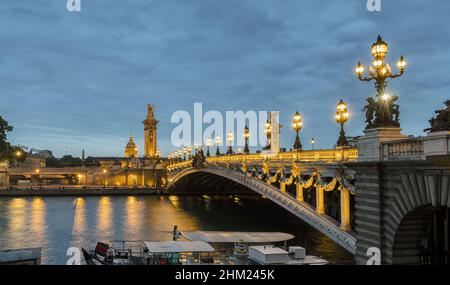 Ponte Alexandre III sul fiume Senna e Hotel des Invalides al tramonto. Ponte decorato con lampade e sculture Art Nouveau ornate. Parigi, p. Foto Stock