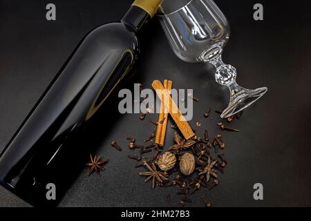 Ingredienti del vino in VIN brulé su sfondo nero. Bottiglia di vino rosso Speices per bevande alcoliche calde, vista dall'alto, Foto Stock