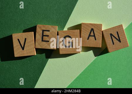 Vegano, parola in lettere di legno, isolato su sfondo verde Foto Stock