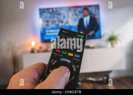 Telecomando TV, la mano con telecomando, vista pov Foto Stock