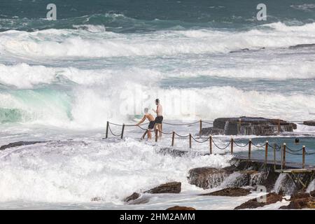 Due ragazzi australiani che giocano e si divertono nel grande surf ad Avalon Beach, NSW, Sydney, Australia Foto Stock