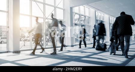 Immagine abstakt della gente d'affari blurred che cammina in una sala moderna Foto Stock