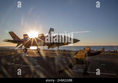 Un Aviation Boatswainʼs Mate (Handling), pranza un F-35B Lightning II, assegnato a Marine Fighter Attack Squadron (VMFA) 122, da USS Makin Island durante le operazioni di addestramento di routine, nell'Oceano Pacifico dal 2 febbraio 2022. In preparazione del loro prossimo dispiegamento con la 13th Marine Expeditionary Unit (MEU) e Makin Island Amphibious Ready Group, F-35Bs da VMFA-122 volò a bordo dell'isola di Makin mentre era in corso con elementi del MEU 13th imbarcato. (STATI UNITI Foto del corpo marino di CPL. Cotogna bisarda) Foto Stock