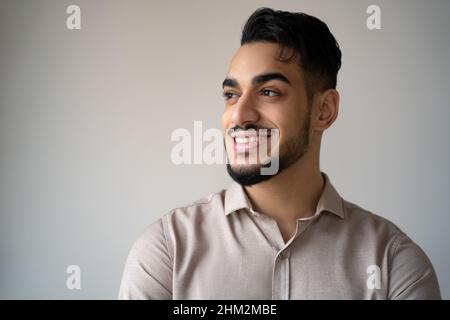 Faccia ritratto di uomo indiano felice guardando da parte con il sorriso toothy isolato Foto Stock