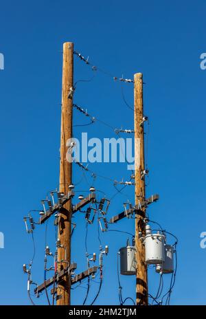 Poli elettrici di alimentazione con filo di linea su sfondo cielo blu Foto Stock