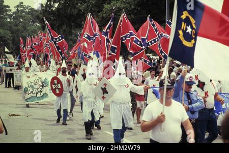 Houston Texas USA, 1990: Membri del gruppo supremacista bianco Ku Klux Klan marzo centro portando bandiere confederate. ©Bob Daemmrich Foto Stock