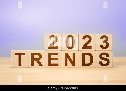 Tendenze 2022 lettere alfabetiche di parole su cubi di legno, sfondo molto peri colore. Nuove tendenze nel mondo, affari, vita, nel 2023 Foto Stock