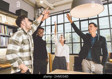 gruppo di dipendenti business office mix gara allegro felice di alzare la mano insieme per il successo finale progetto fatto concetto Foto Stock