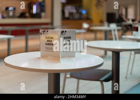 Cartello con la parola "social distance" sul tavolo del ristorante. Istruzione di distanziamento sociale contro la diffusione. Nuovo normale riapri Mall, scuola. Nessuno Foto Stock